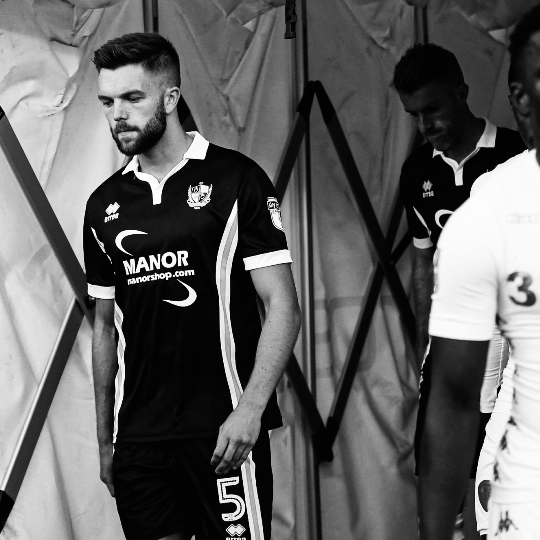 Former professional footballer Joe Davis walks onto the pitch wearing a Port Vale strip, the picture is black and White