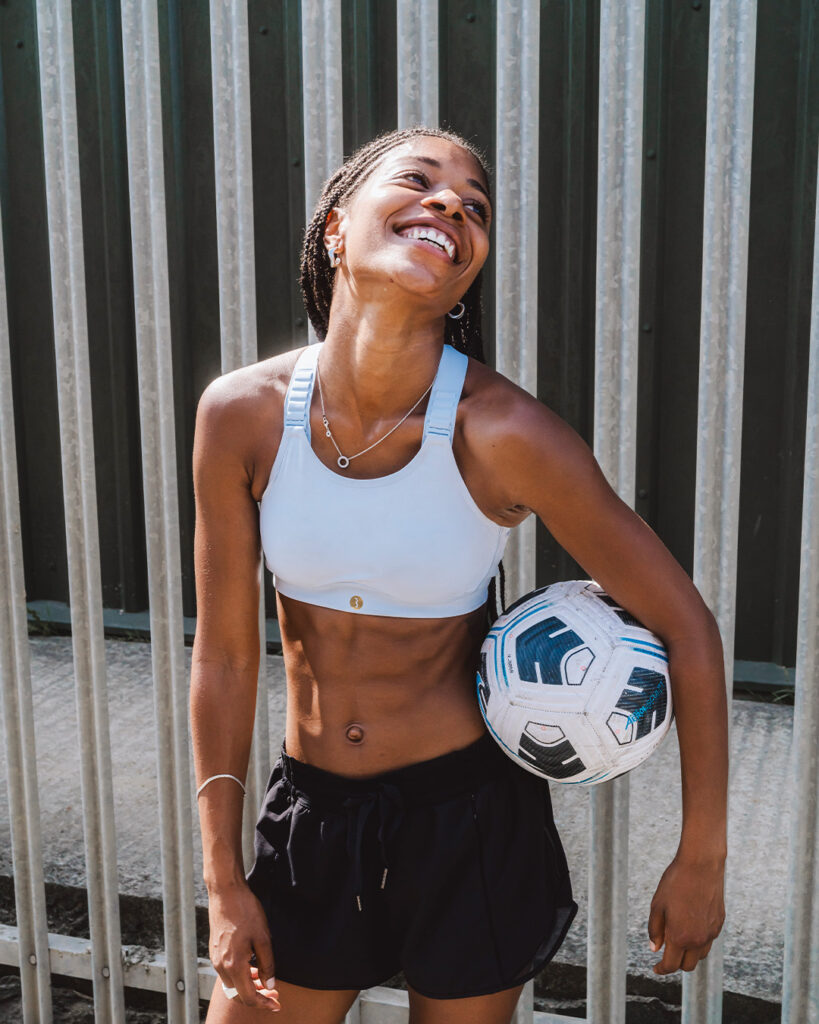 Woman wearing sports bra and holding a football
