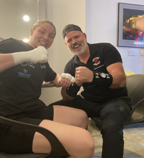 Lauren Price (left) posing with Ian Gatt (right) after doing the wraps for her hands before a fight