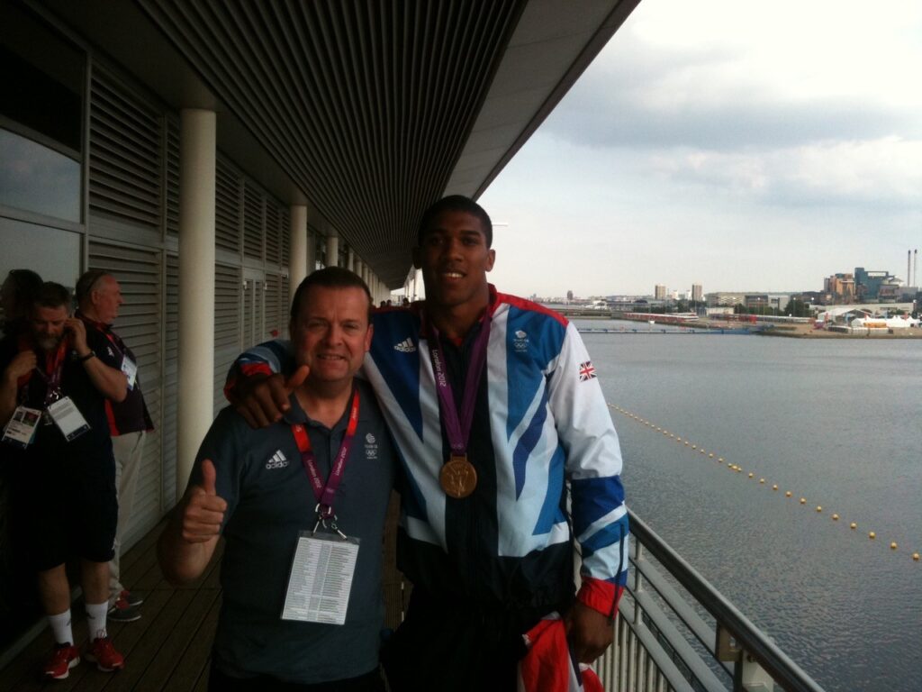 Richard Prescott (right) standing next to Anthony Joshua who is wearing his gold medal from the 2012 Olympics fight