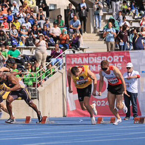 Great Britain's 100 metre blind sprint record holders James Ledger, wearing a red and white running vest, and guide runner Greg Kelly, wearing a yellow vest are attached a 6cm running cord as they leave the blocks and start the race.