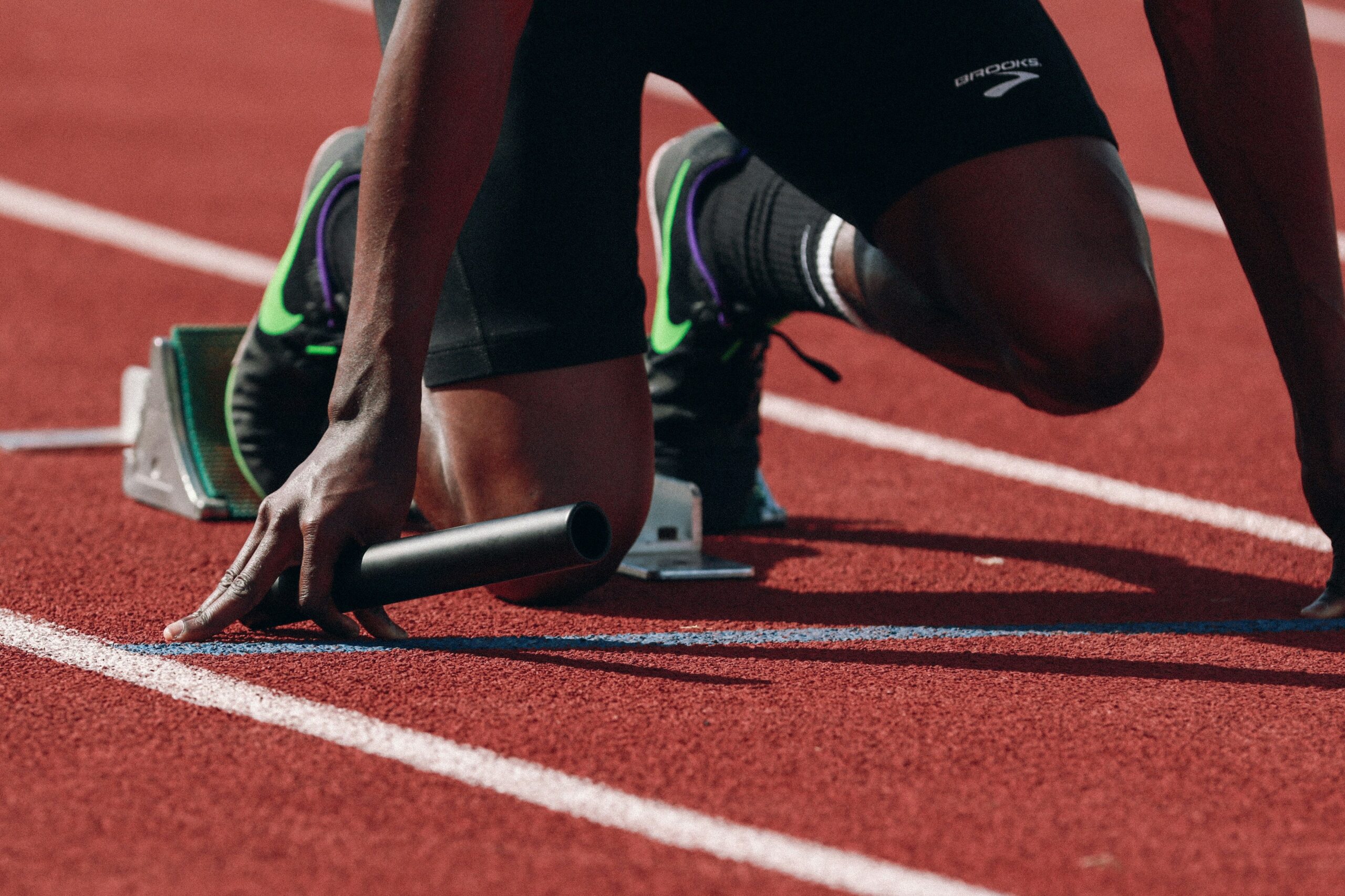 Athlete preparing for race on a track with starting blocks