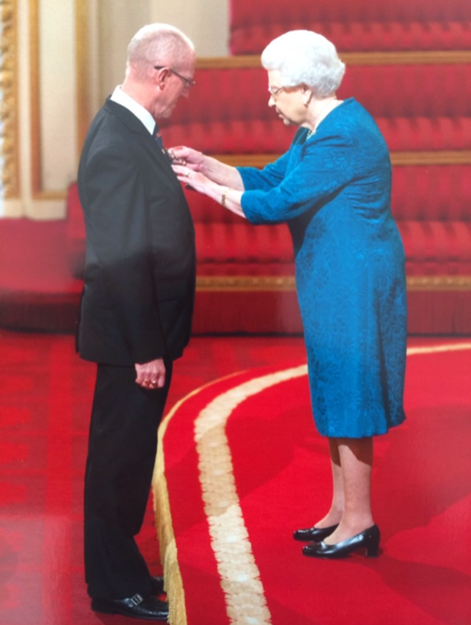 Athletics coach John Powell recieves his badge of honour and MBE from the Queen.
