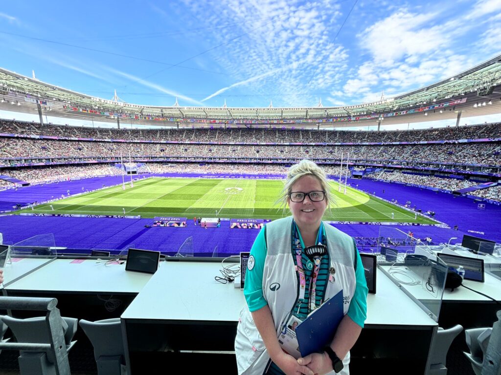 Karolyn Gaston at the Paris 2024 olympics with a rugby stadium in the background
