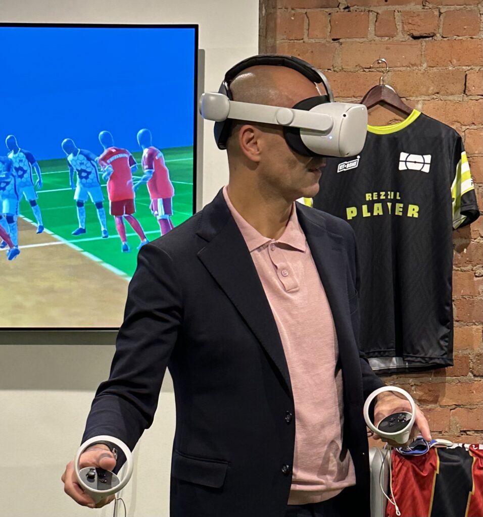 Picture shows a man using a VR headset in a studio with Rezzil branded on a t-shirt in the background